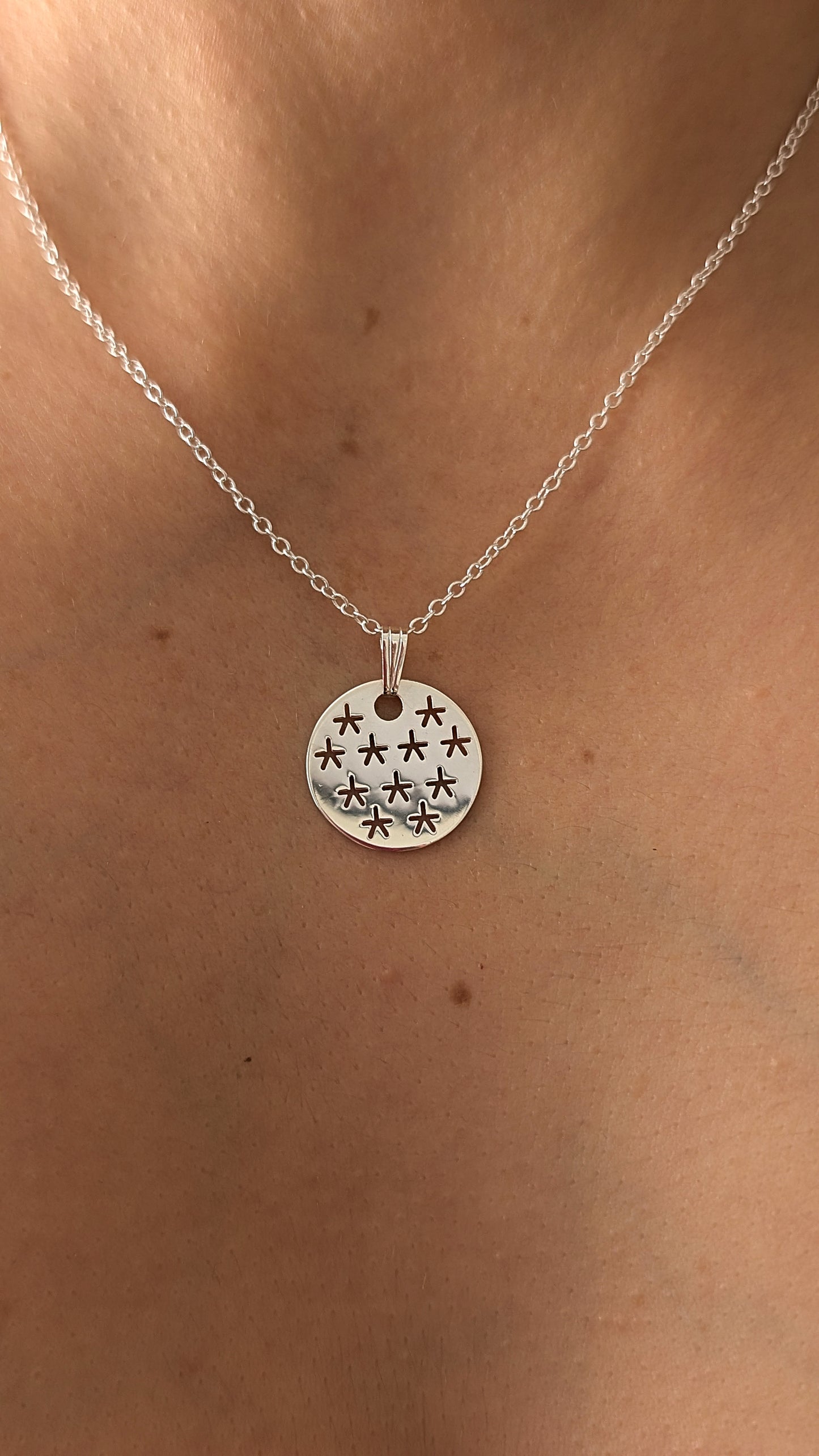 close up of stars pendant necklace on woman