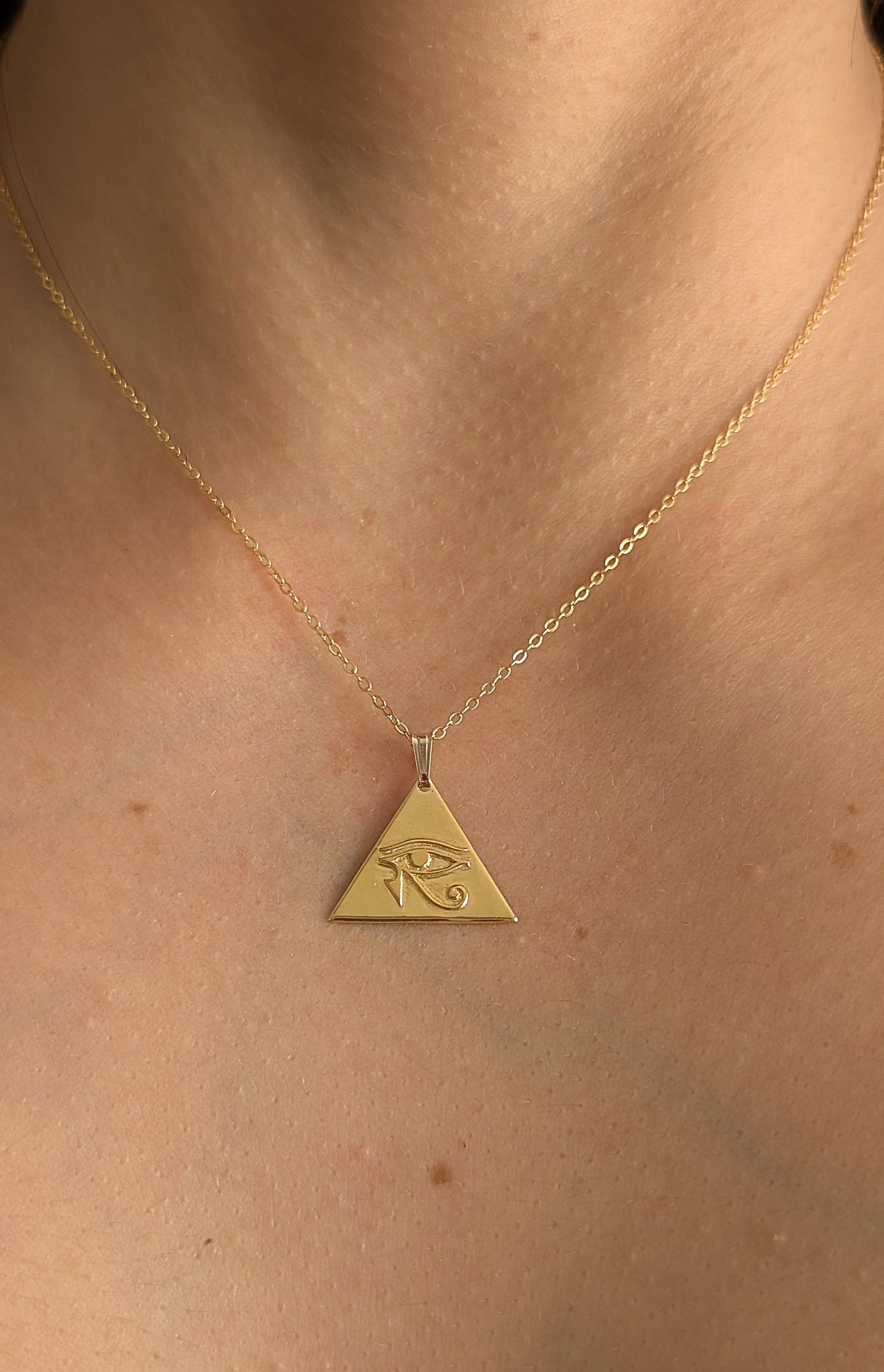 close up of eye of horus pendant on woman's skin