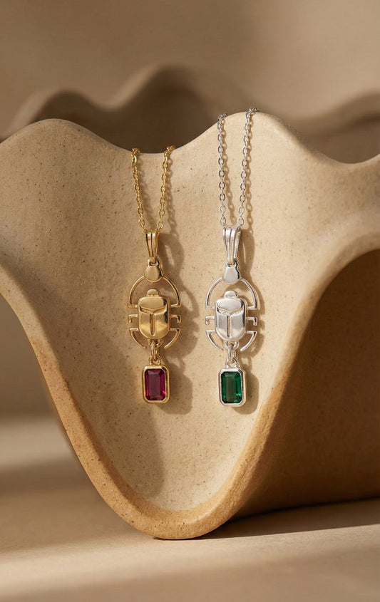 Gold and silver scarab necklaces with red and green stones
