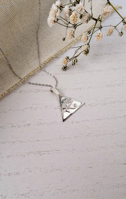 silver eye of horus pendant on wooden background