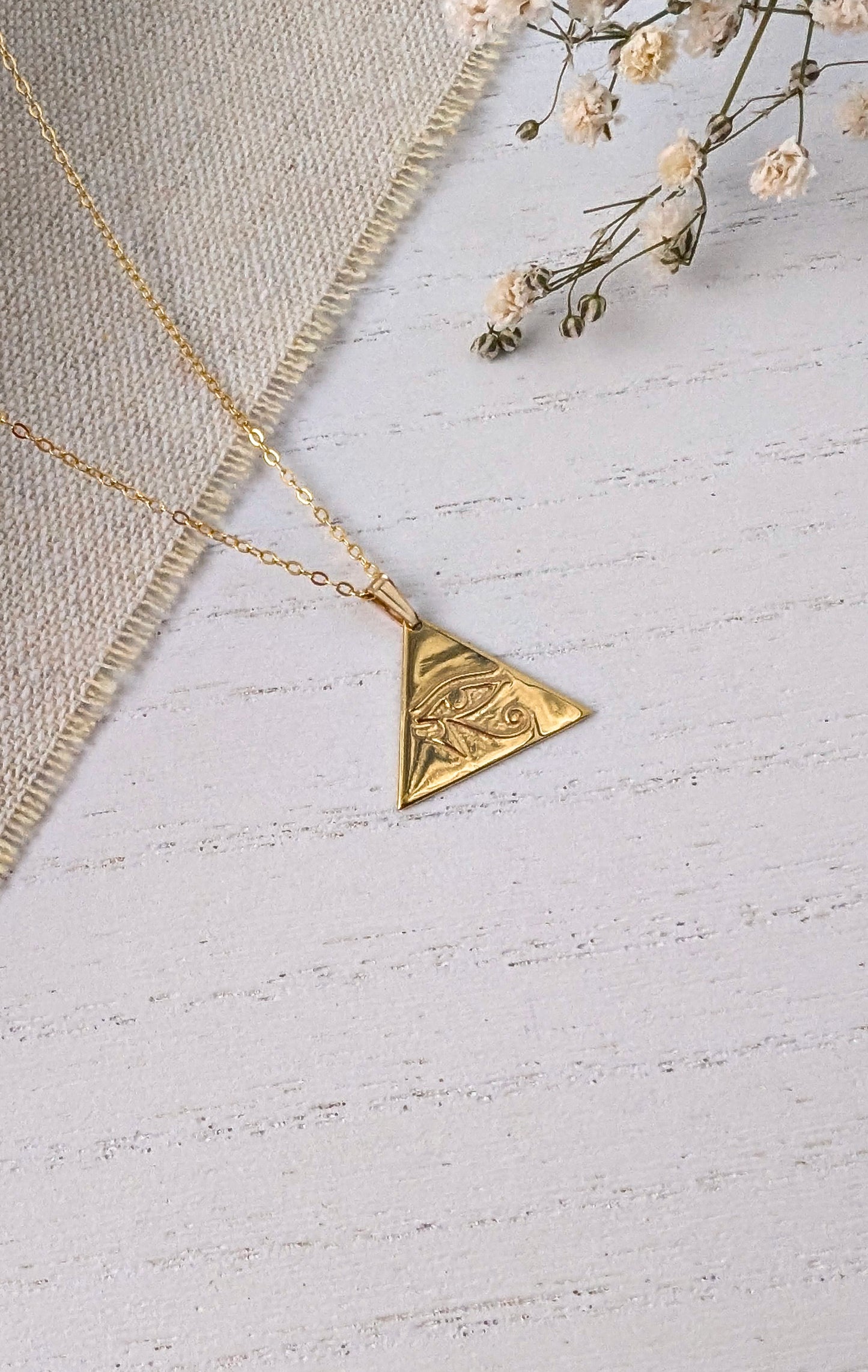 gold eye of horus pendant on wooden background