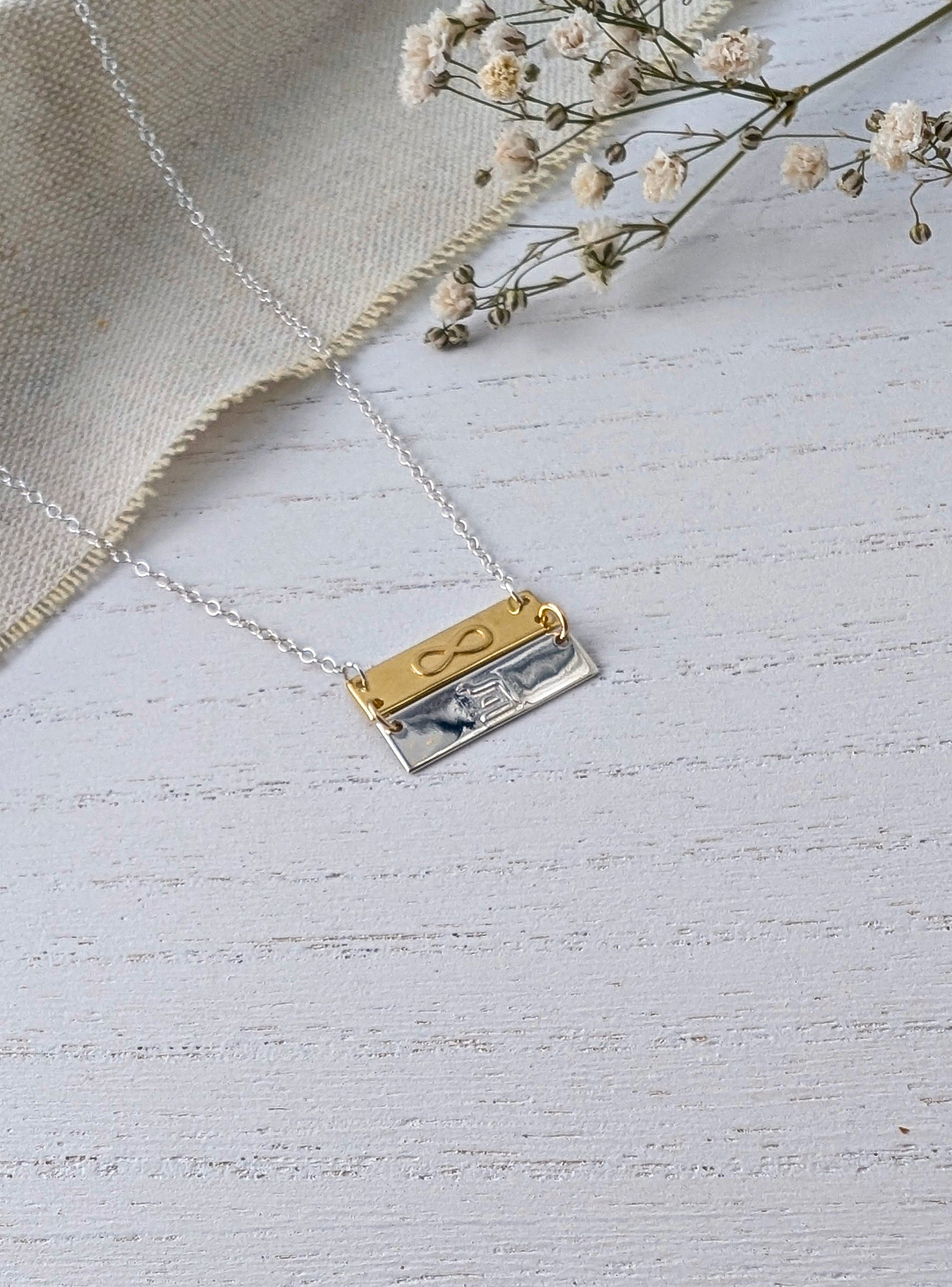 infinity eternity pendant necklace on wooden surface