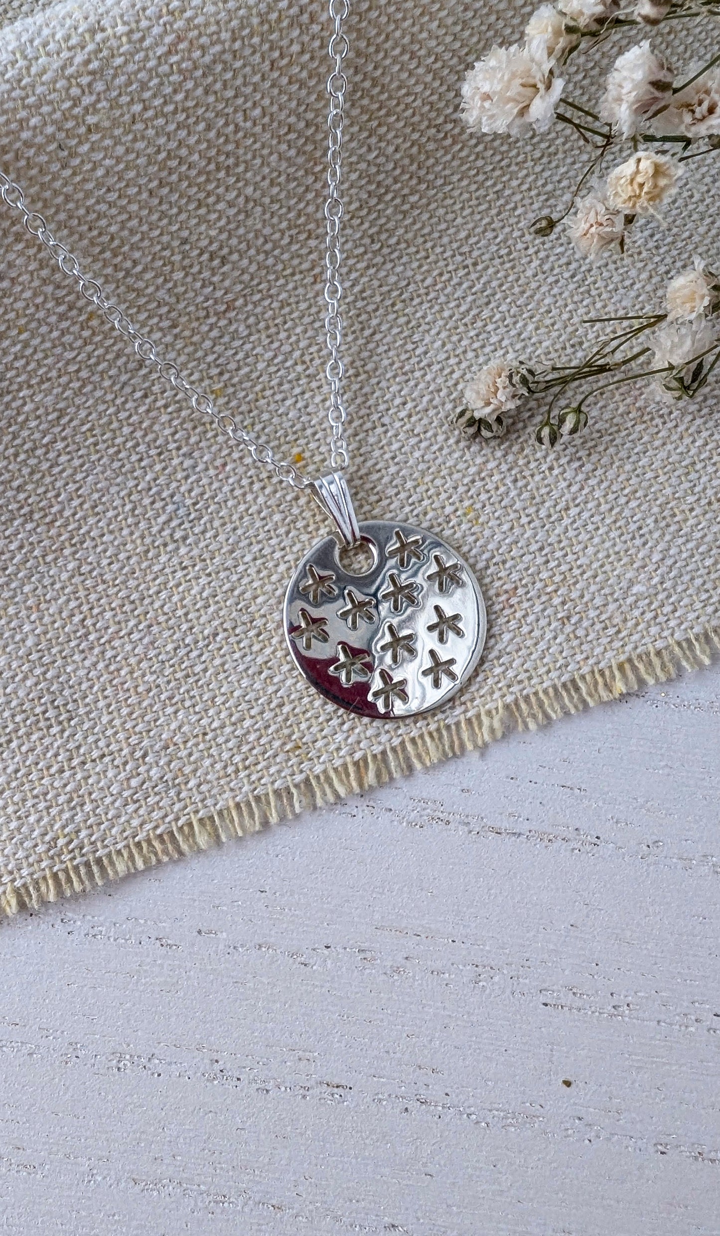 silver stars pendant on beige fabric
