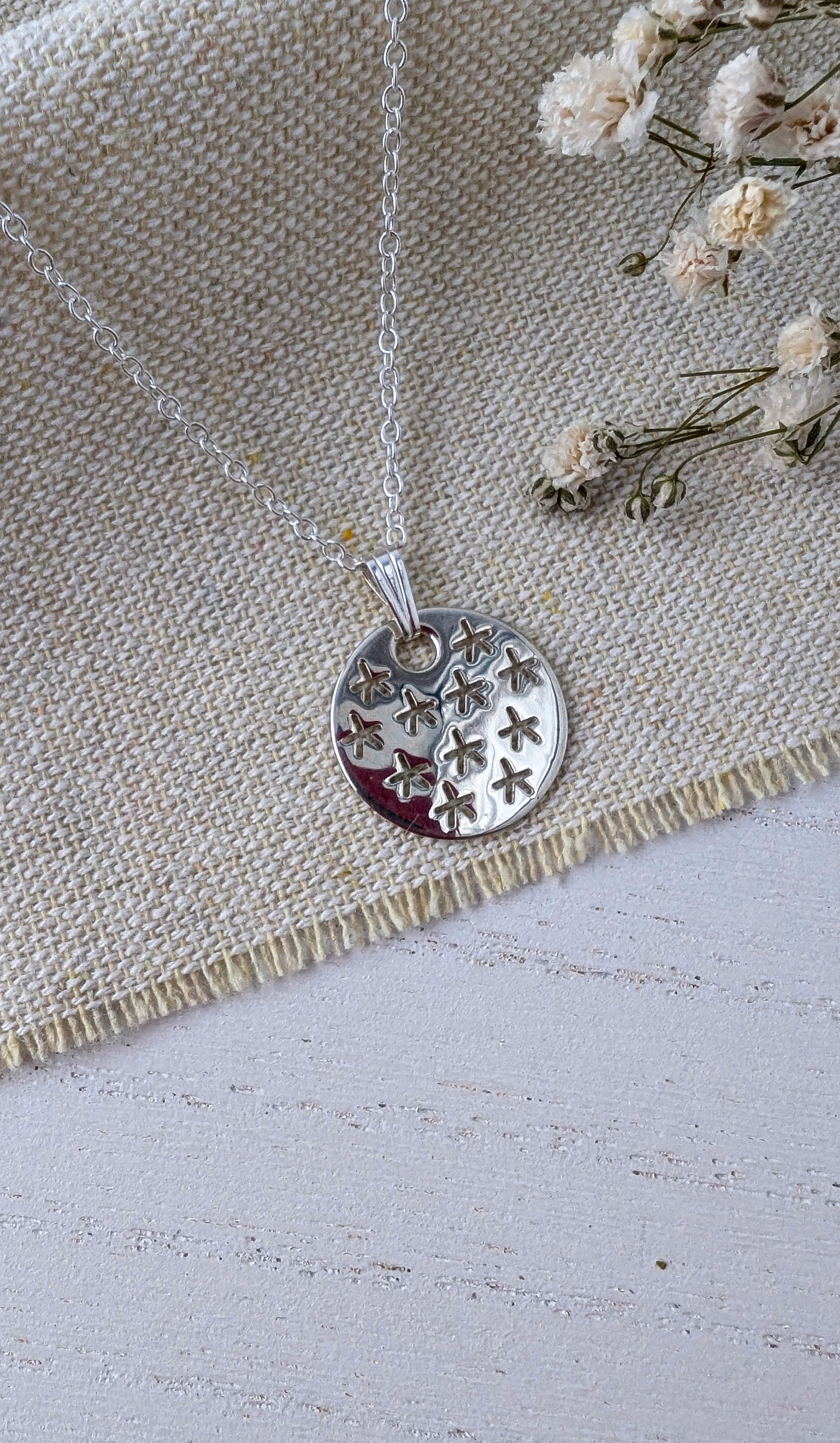 silver stars pendant on beige fabric