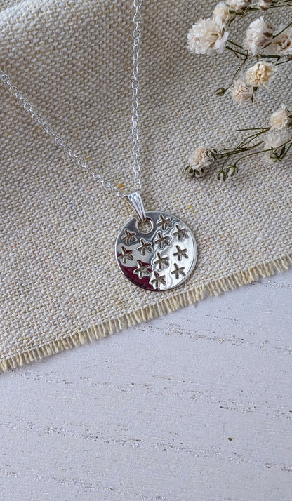 silver stars pendant on beige fabric