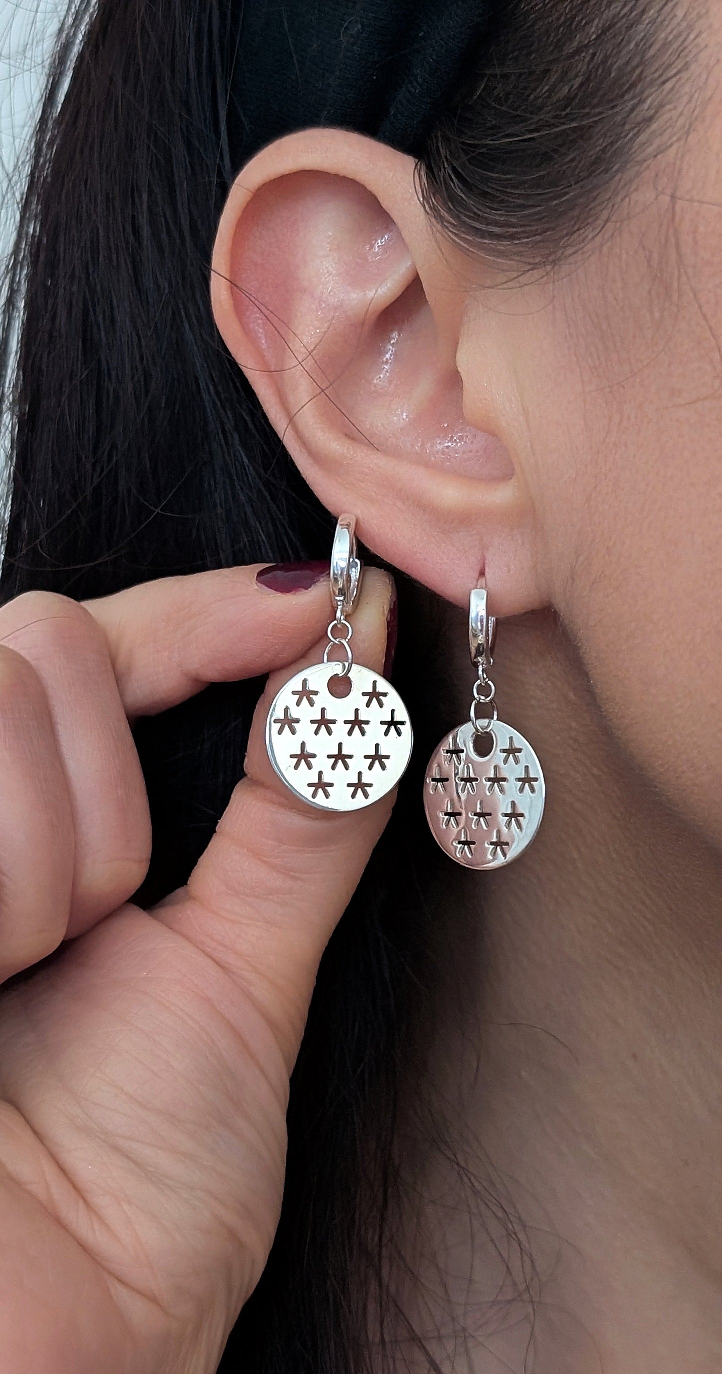 close up of silver stars earrings worn by woman