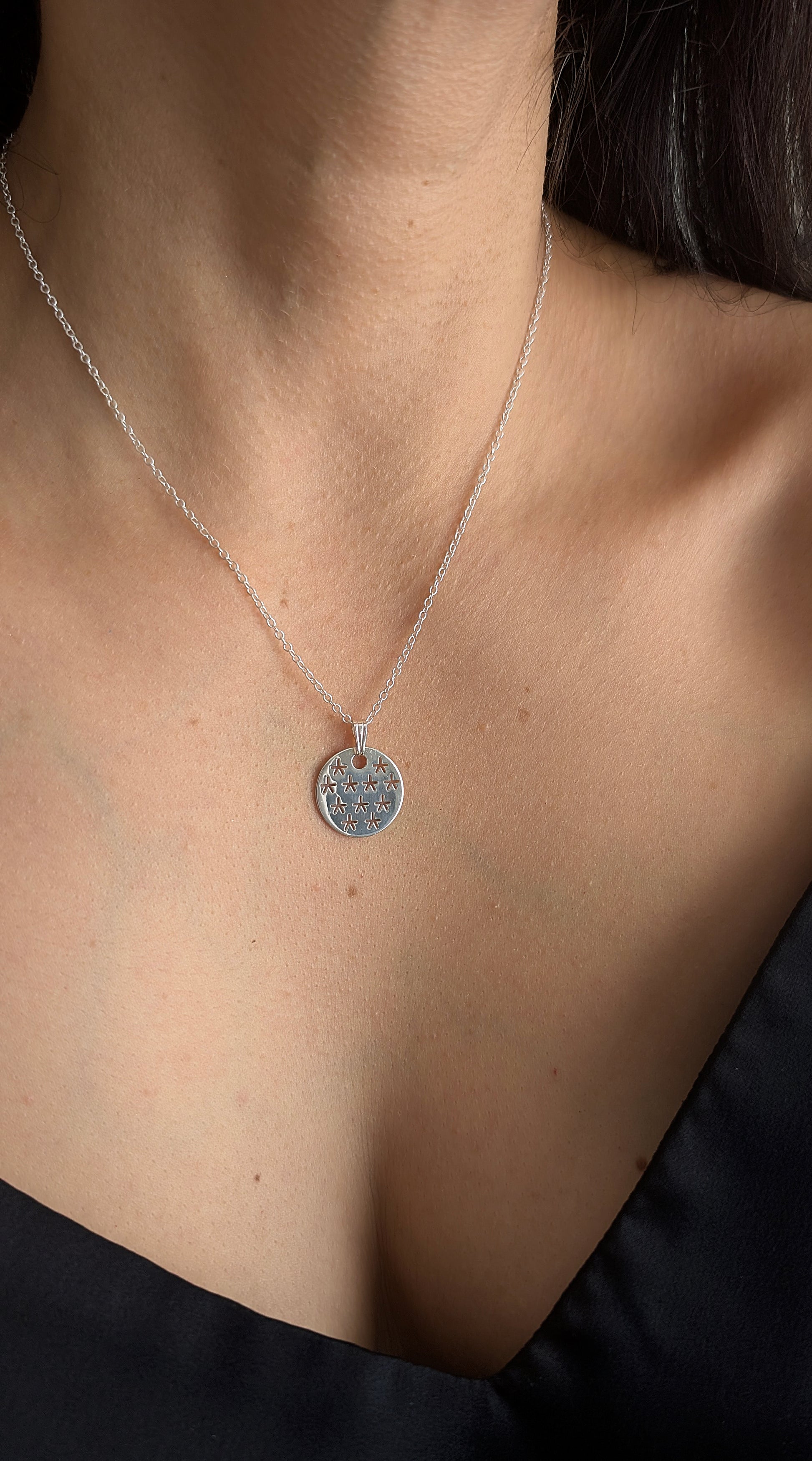 silver stars pendant worn by woman