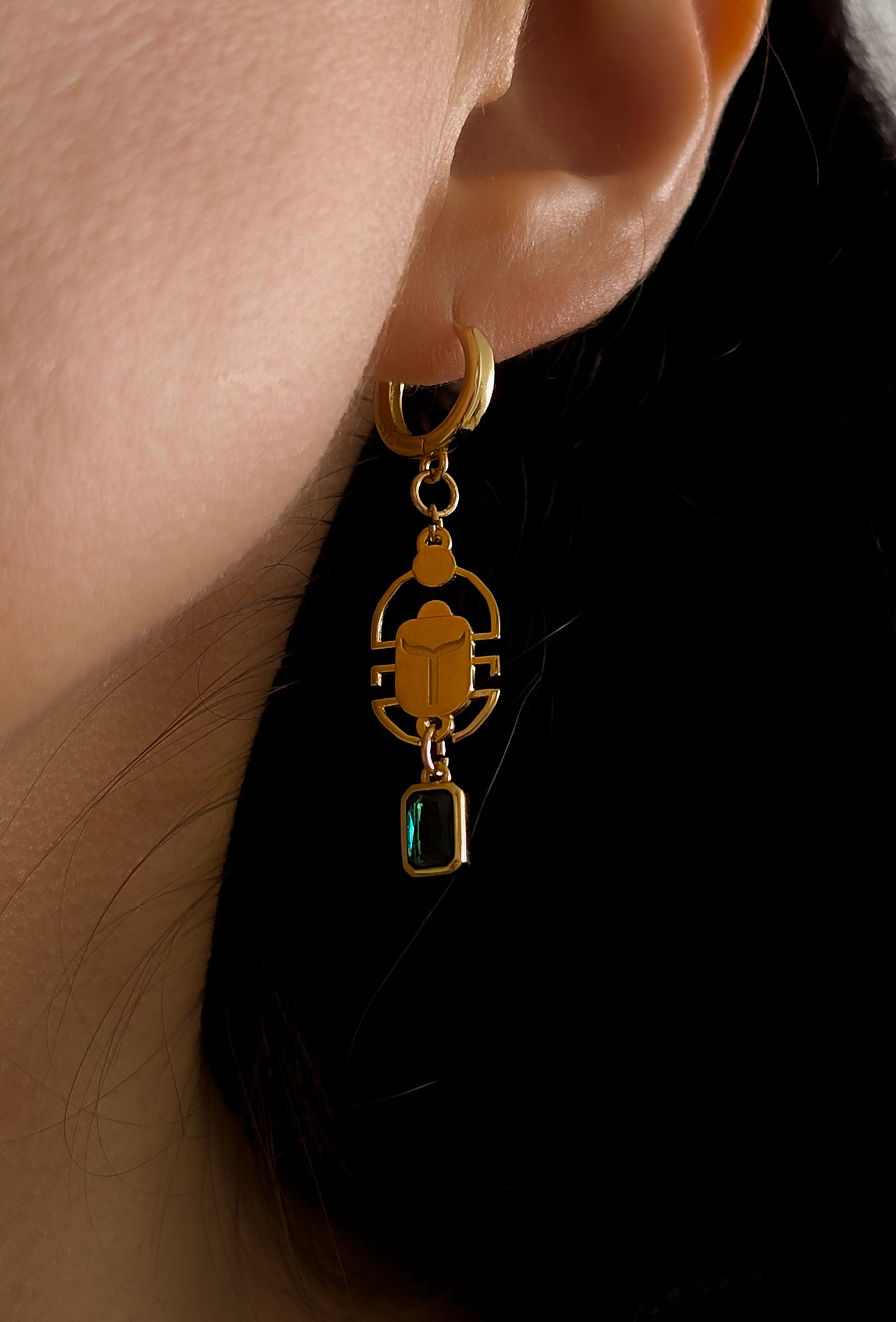 close up photo of woman wearing a scarab earring
