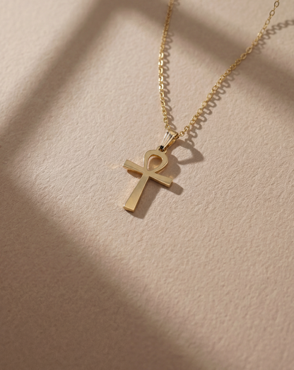 Gold ankh necklace  on a beige background