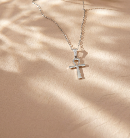 Silver necklace with ankh pendant on a beige background