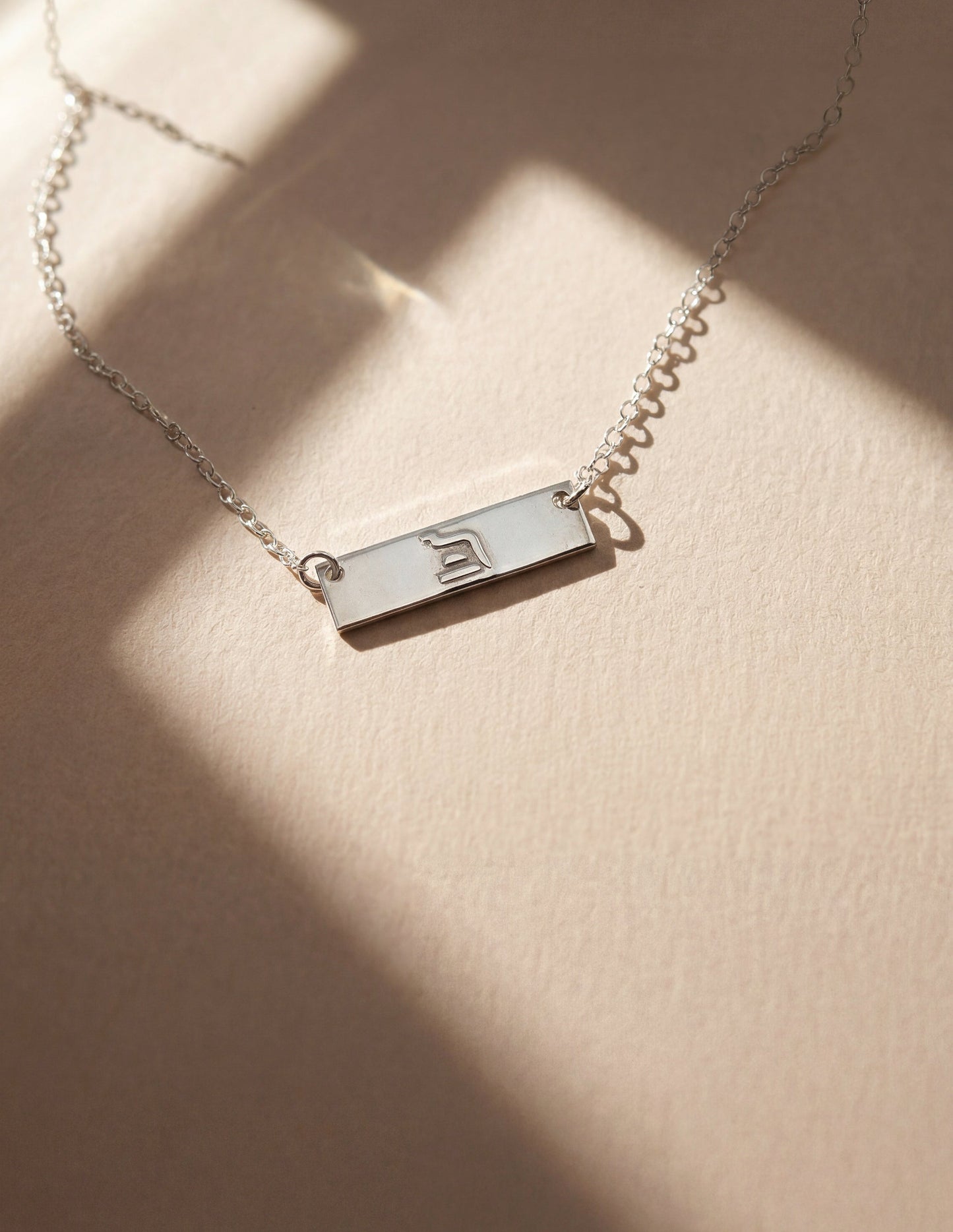 silver eternity necklace on beige background