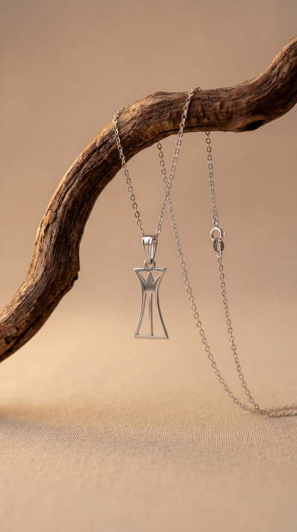 Silver lotus column necklace  on a wooden branch against a beige background