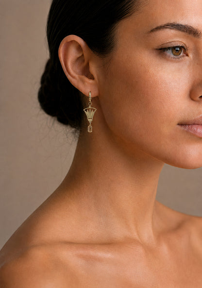 Close-up of a woman wearing a lotus earring with a neutral background