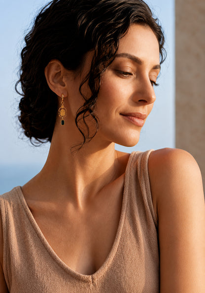 Woman wearing scarab earrings with a blurred background