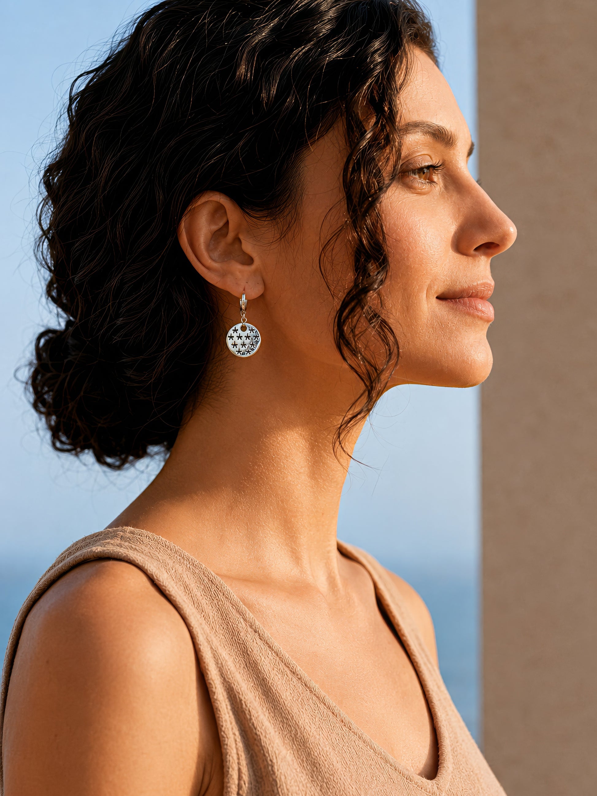 silver earrrings with stars pendant worn by woman